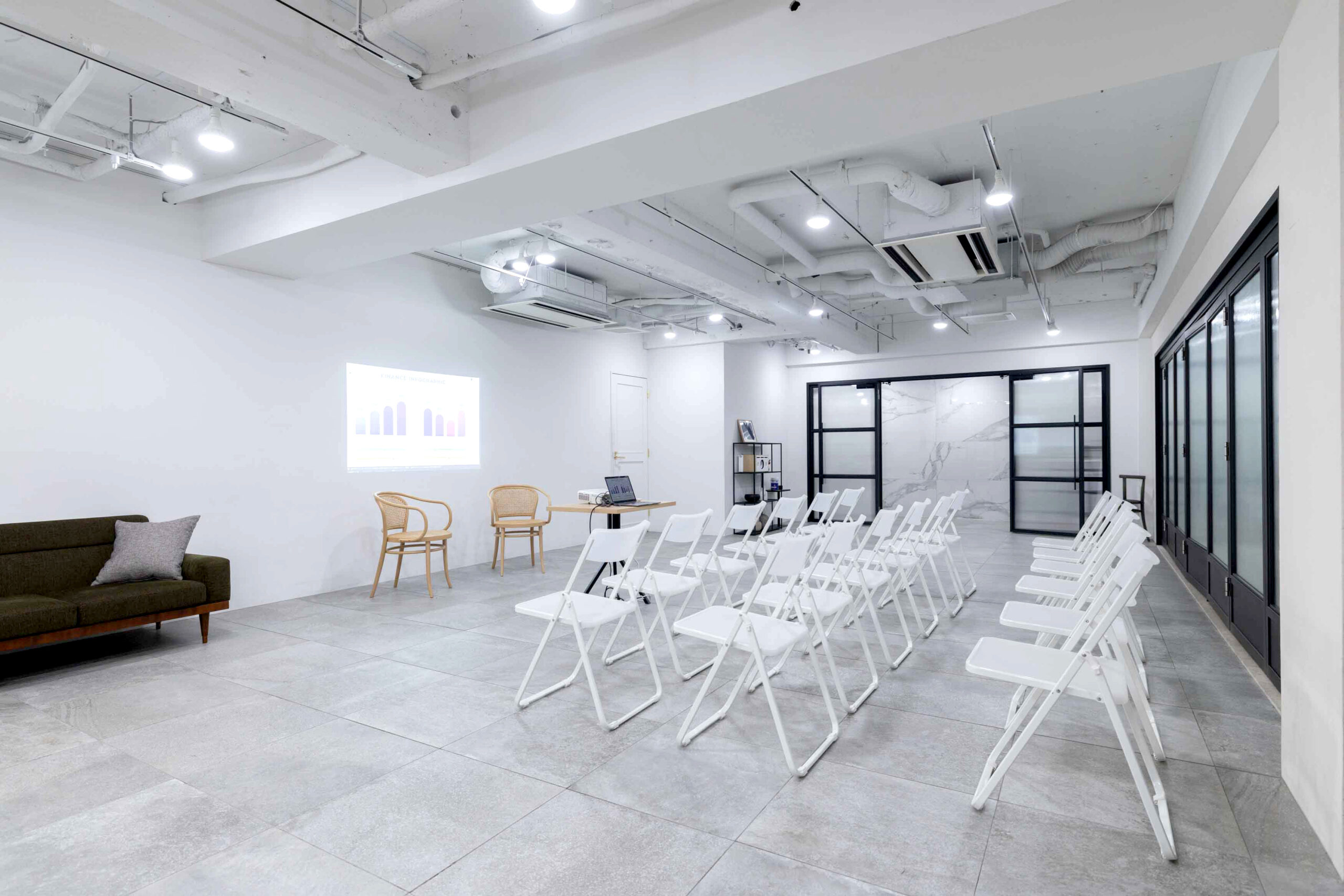 プロジェクタを使ったイベントシーン。簡易椅子30脚並んでいる