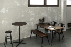 モルタル風の壁面前に配置された、カフェ風のテーブルセット