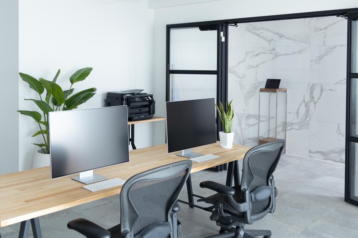 デスク、モニター、チェア、プリンタが設置されたオフィス写真