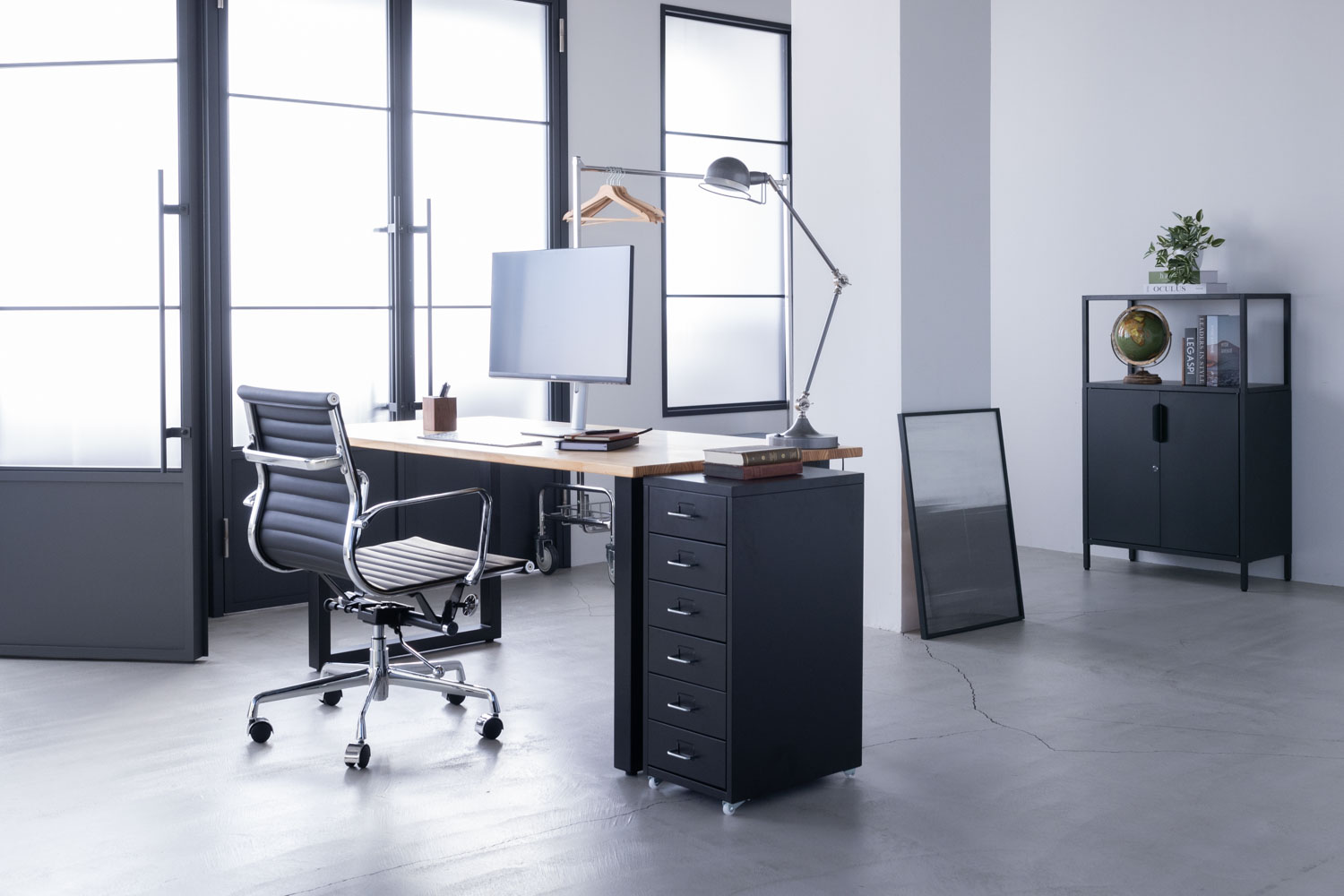 自然光で明るいクールな空間に、オフィス風のデスクセットが置かれた写真