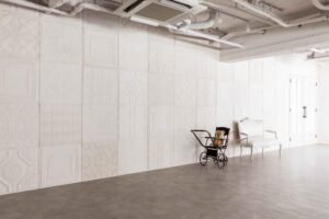 白のティンパネルが施された壁面前に、アンティーク家具が並ぶ写真