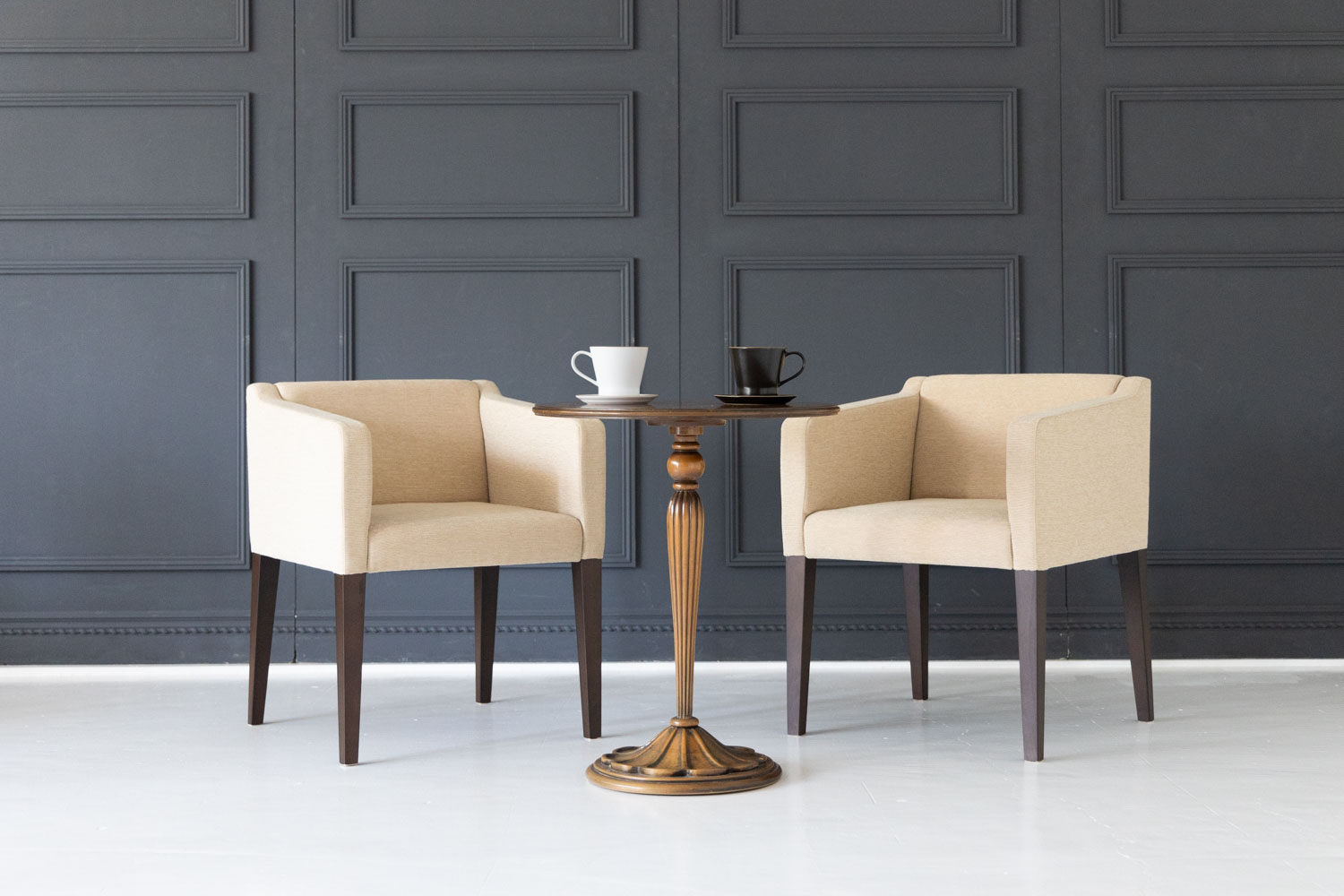 ブルーグレーの壁前に置かれたラウンジテーブルセット