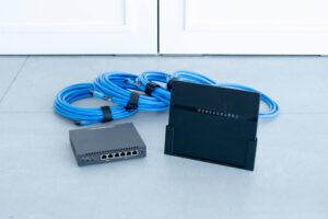 ルーター、ハブ、LANケーブルが並んでいる写真