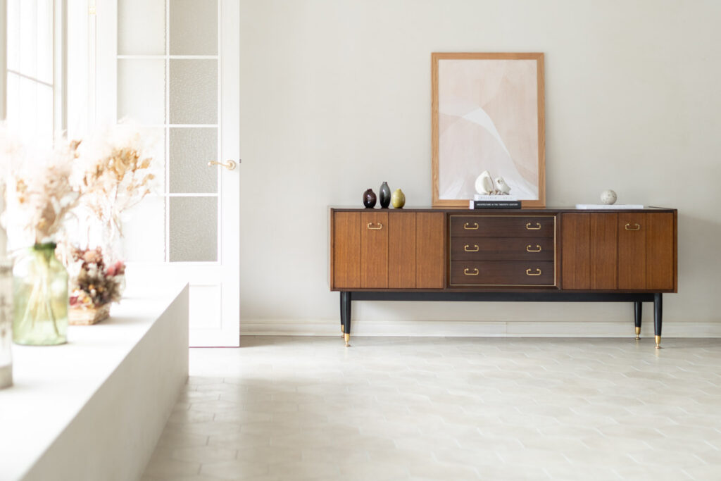 アーリーバードで優しい自然光が入りキャビネットと白壁が写っている写真。