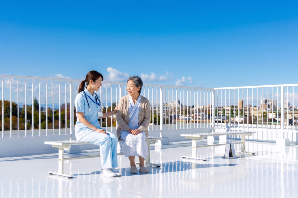 屋上のベンチで患者さんと看護師さんが話しているシーン