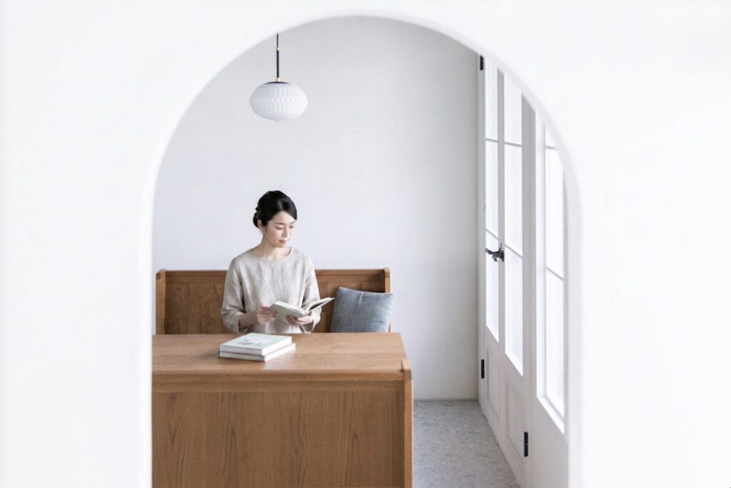 木製ベンチで女性が本を読んでいる写真