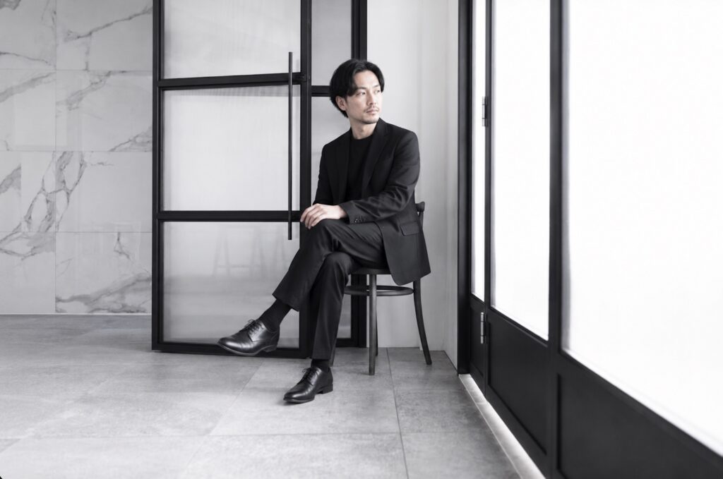男性がスーツで椅子に座っている写真